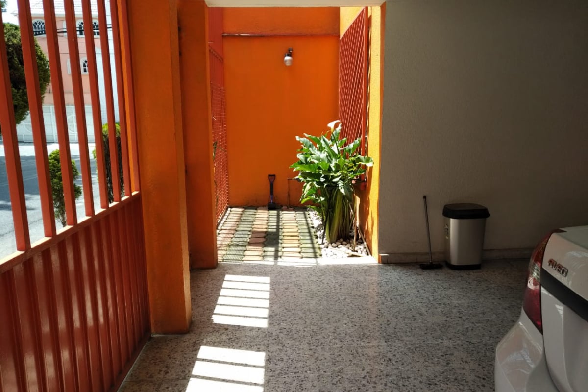 Jardín frontal y cochera para dos autos de la residencia en venta en Metepec.